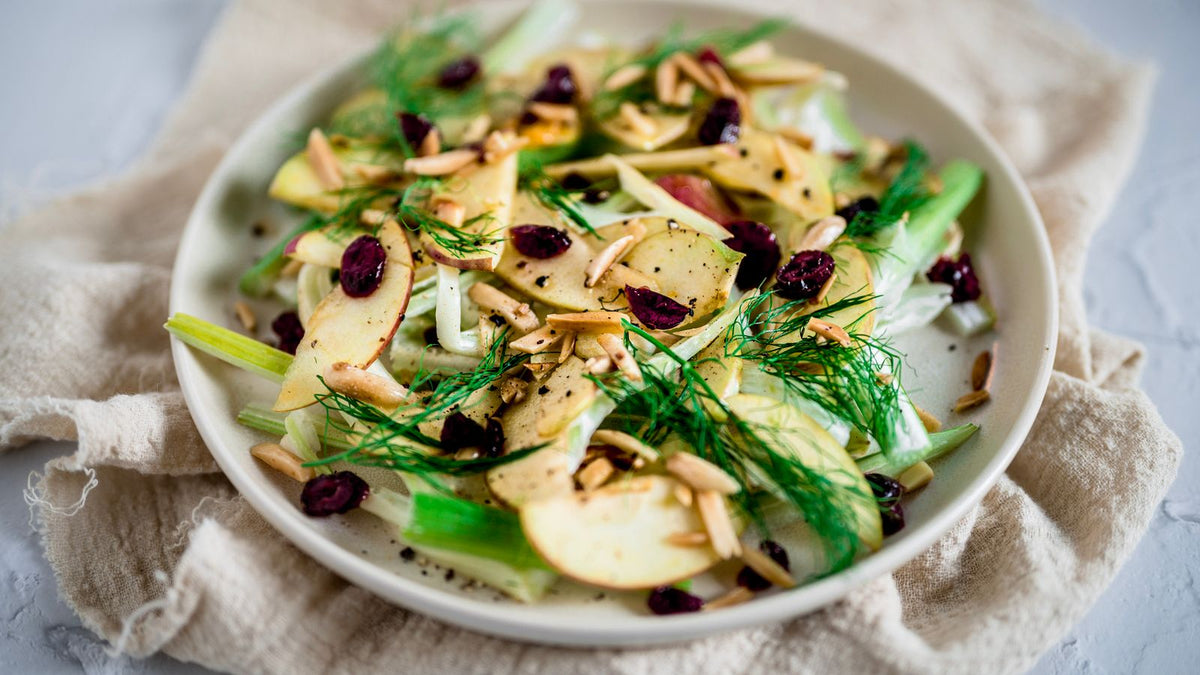 Salade fraîche de fenouil émincé et pomme servie dans une assiette claire.