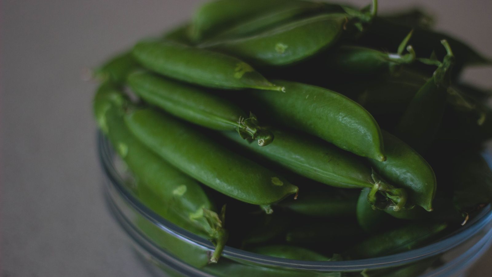 Haricots verts frais dans un bol en verre, prêts à être cuisinés de plusieurs façons.