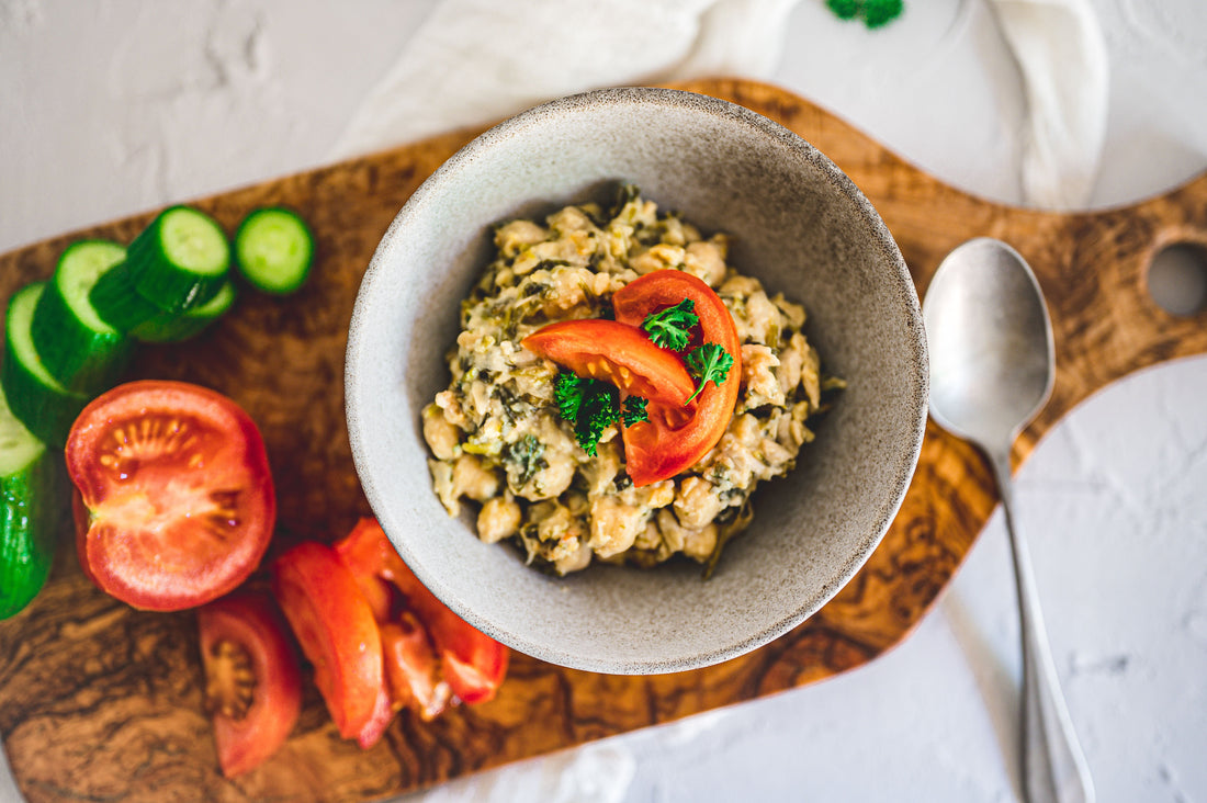 Bol de pois chiches avec tomates et légumes pour illustrer des recettes faciles et économiques avec des pois chiches en boîte.