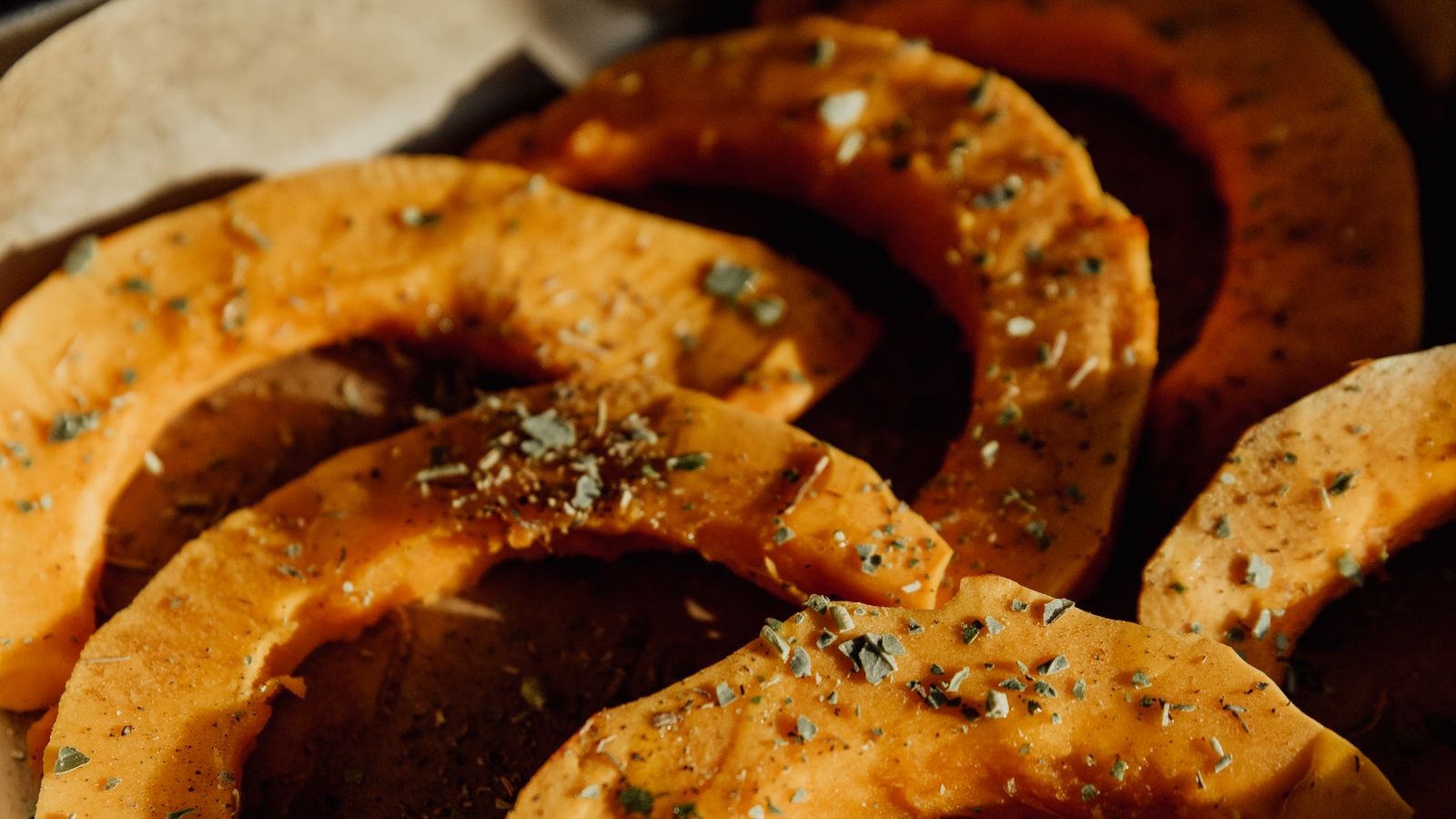 Tranches de courge rôties et assaisonnées dans un plat, pour des recettes d’automne simples.