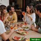 Groupe d’amis partageant un apéritif dînatoire avec cocktails, tartines et bouchées sur une terrasse conviviale.