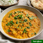 Curry végane de lentilles corail servi avec riz et pain naan, recette végétale crémeuse, économique et réconfortante.