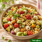 Salade de pâtes estivale avec tomates rôties, courgettes, mozzarella, avocat, herbes fraîches et pignons.