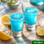 Deux shooters bleus servis avec glaçons et quartiers de citron, boisson fraîche et colorée pour l’apéritif.