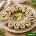 Wraps apéritifs au saumon fumé, concombre et fromage frais, découpés en bouchées et dressés en cercle sur une assiette.